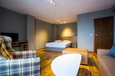 a hotel room with a bed and a couch at Sunny Hills Ski&Wellness in Pamporovo