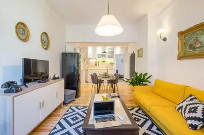 a living room with a yellow couch and a table at Downtown Wanderlust Apartment in Sofia