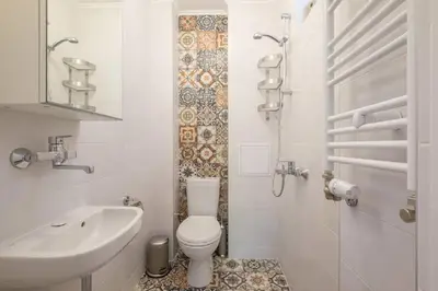 a white bathroom with a toilet and a sink at Downtown Wanderlust Apartment in Sofia