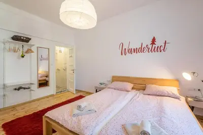 a bedroom with a bed and a sign on the wall at Downtown Wanderlust Apartment in Sofia