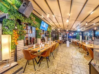 a restaurant with tables and chairs and plants on the walls at Hotel Elit in Devin