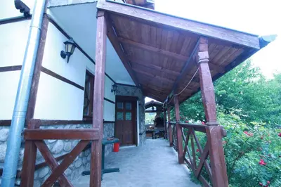 a porch of a house with a wooden roof at Belcheva kashta in Banya