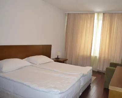 a bedroom with a large white bed and a window at Bellevue Residence Apartments in Bansko