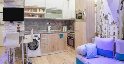 a kitchen with a washing machine and a purple couch at City center Apartment in Sofia
