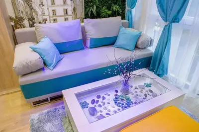 a purple couch with pillows and a fish pond at City center Apartment in Sofia