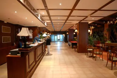 a lobby of a restaurant with a woman standing at a counter at Hotel Prespa in Pamporovo
