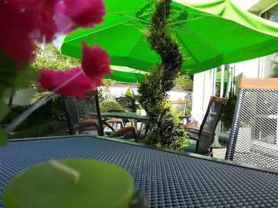 a table with green umbrellas on a patio at Hotel Galant in Sofia