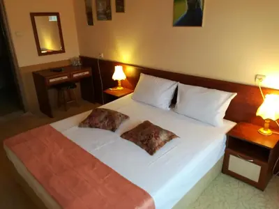 a bedroom with a large white bed with two pillows at Hotel Galant in Sofia