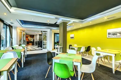 a restaurant with yellow walls and tables and chairs at Saint George Palace Aparthotel in Bansko