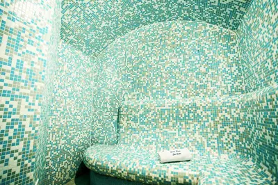 a chair in a room with a tiled wall at Pirin River Ski, Fun and Family in Bansko