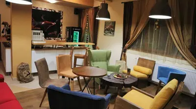 a living room with colorful chairs and a table at Pirin River Ski, Fun and Family in Bansko