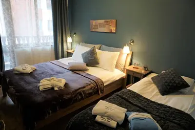 a hotel room with two beds with towels on them at Pirin River Ski, Fun and Family in Bansko