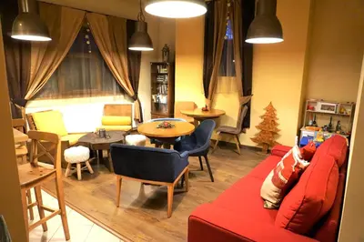 a living room with a red couch and a table at Pirin River Ski, Fun and Family in Bansko