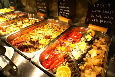 a buffet with several trays of different types of food at Pirin River Ski, Fun and Family in Bansko