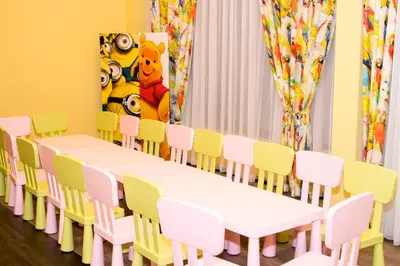 a classroom with white tables and chairs and a painting at Hotel Etropolia in Etropole