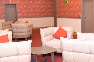a waiting room with white chairs and a table at Hotel Etropolia in Etropole