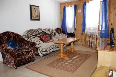 a living room with a couch and a table and chairs at Hotel Elitza in Pamporovo