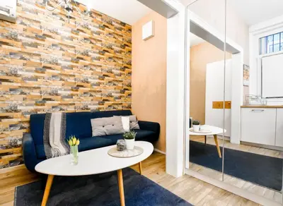 a living room with a blue couch and a brick wall at 2BDR Heart of Sofia AC Fully Equipped in Sofia