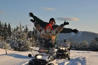 a man and a woman riding a motorcycle in the snow at Elitza Villa in Pamporovo