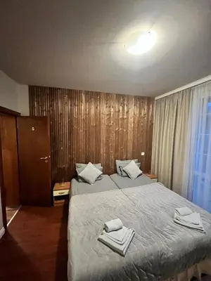 a hotel room with two beds with towels on them at Zasheva Kushta Guesthouse in Bansko