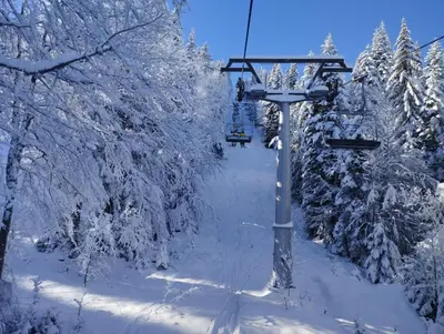 a ski lift in the snow with snow covered trees at Studio in Hotel Laplandia in Pamporovo