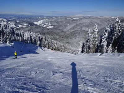a shadow of a person skiing down a snow covered slope at Studio in Hotel Laplandia in Pamporovo