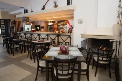 a restaurant with tables and chairs and a fireplace at Studio in Hotel Laplandia in Pamporovo