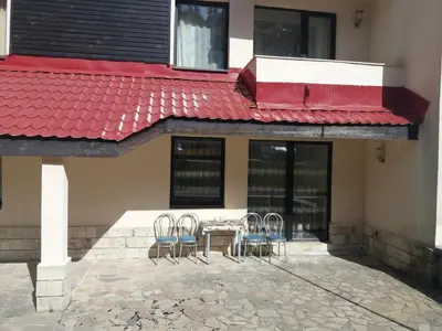 a patio with chairs and a table with a red roof at Studio in Hotel Laplandia in Pamporovo