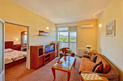 a hotel room with a bed and a living room at Augusta SPA Hotel in Hisarya