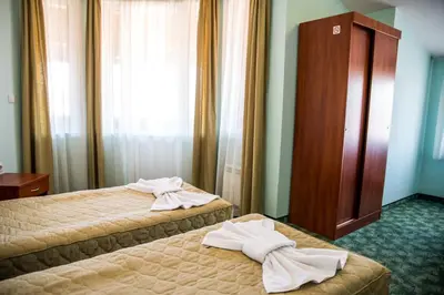 two beds in a hotel room with towels on them at Bariakov Family Hotel in Bansko