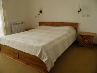 a bedroom with a wooden bed and two tables at Pripetzite Hotel in Godlevo