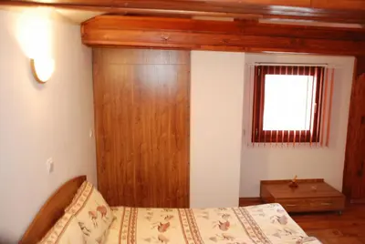 a bedroom with a bed and a wooden wall at Vien Guest House in Bansko