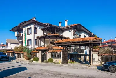 a large house with a gate in front of it at Grami Hotel in Bansko