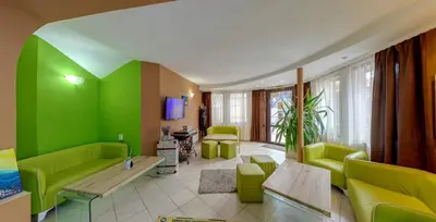 a living room with green furniture and a green wall at Grami Hotel in Bansko