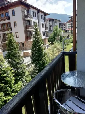 a balcony with a table and a view of a city at Fortuna Apartments in Bansko