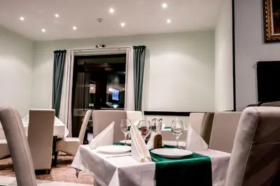 a dining room with white tables and chairs at Hotel Bellevue - Half Board in Pamporovo