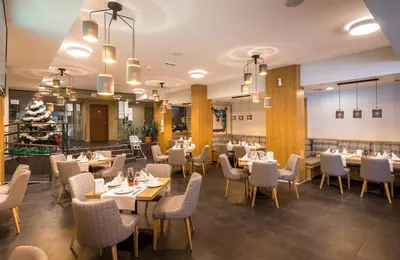 a dining room with tables and chairs and a restaurant at St George Ski & Holiday - Half Board & All Inclusive in Bansko