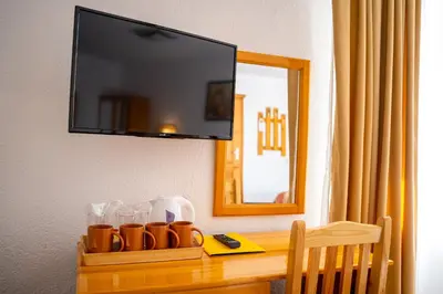 a shelf with cups on a table with a television at Vezyuva House in Bansko