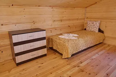 a bedroom with a bed and a dresser in a room at Guesthouse Vazrozhdenski kashti in Manastir