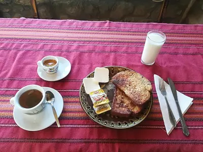 a table with a plate of food and a cup of coffee at Guesthouse Vazrozhdenski kashti in Manastir