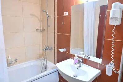 a bathroom with a sink and a shower and a tub at Apart Hotel Orbilux in Bansko