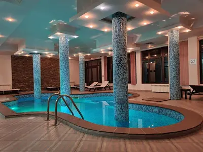 a pool in the middle of a hotel with pillars at Apart Hotel Orbilux in Bansko