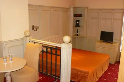 a small bedroom with a bed with a table and a chair at Hotel Bordo in Plovdiv