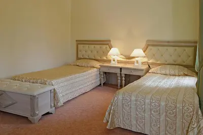 a room with two beds and a desk with two lamps at Hotel Bordo in Plovdiv