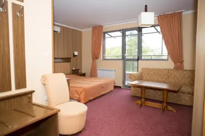 a hotel room with a bed and a couch at Hotel Bordo in Plovdiv
