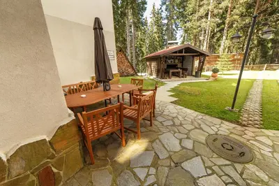 a patio with a table and chairs and an umbrella at Monastery 2 Aparthotel in Pamporovo