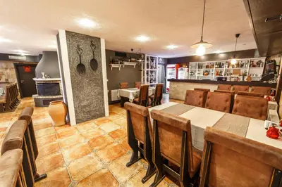 a restaurant with a dining room with tables and chairs at Monastery 2 Aparthotel in Pamporovo