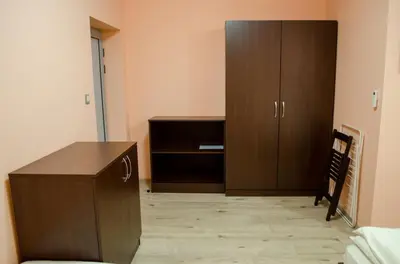 a room with a wooden cabinet and a desk at Guest House Dinevi in Sapareva Banya