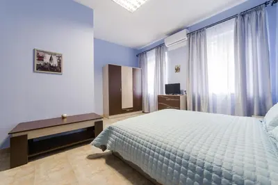 a bedroom with a bed and a desk and window at Семеен хотел Пауталия in Kyustendil