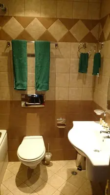 a bathroom with a toilet and a sink and green towels at TES Royal Plaza Apartments in Borovets